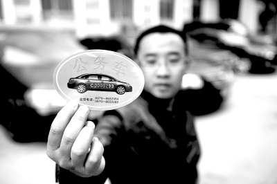 青海省某单位一名驾驶员在展示领取的公务用车标识。记者　张宏祥　摄