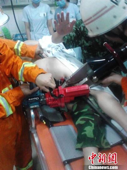 2米钢筋穿过伤者的大腿，消防官兵使用专业设备对钢筋进行固定和剪切。 刘俊 摄
