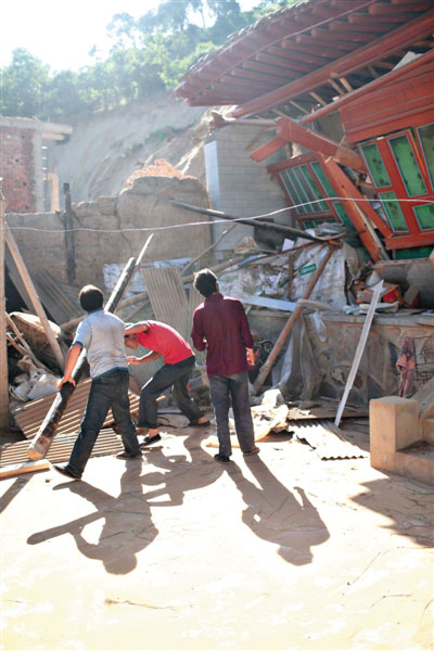 昨日，马家沟村，村民在地震后从坍塌的房屋内搬运一些有用的家具。