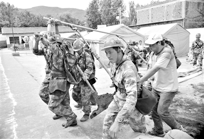 昨日,救援官兵清理小学场地,帮助当地群众搭设帐篷。 新华社发
