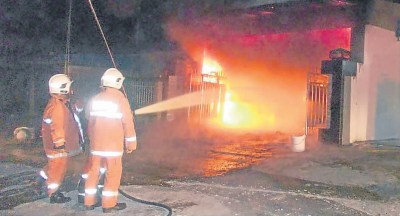 消拯员赶赴疑遭纵火的双层排屋现场灭火。马来西亚《南洋商报》