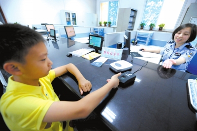 北京警方启动居民身份证登记指纹信息第一天,一名小朋友在派出所登记