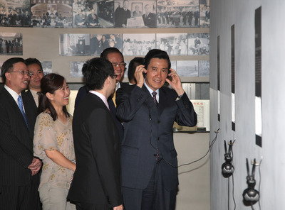 身兼中国国民党主席的马英九（右）27日前往中央党部，出席党史馆乔迁暨揭幕仪式后，拿起耳机聆听孙中山的录音谈话。台湾“中央社”图