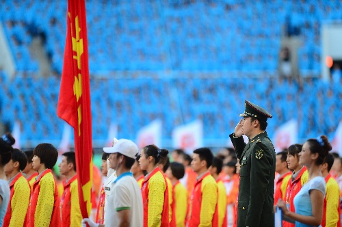 这是中国人民解放军体育代表团旗手王治郅在开幕式上.