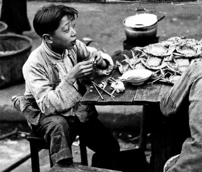 这张上世纪40年代的老照片只是记录了一名小男孩正在吃螃蟹 摄影/沃特·阿鲁法特(Walter Arrufat)