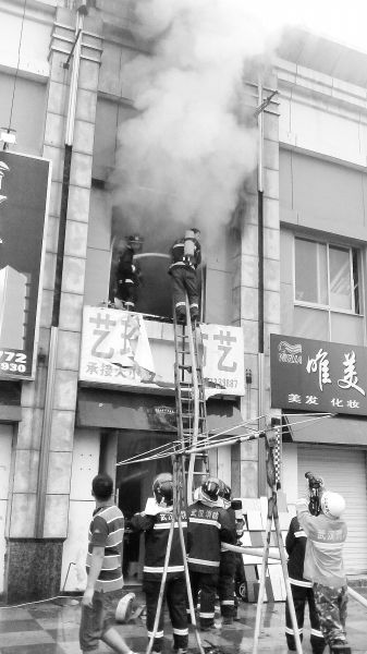 消防员架梯灭火。见习记者孔轩摄