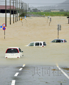 今年第18号台风“万宜”在日本爱知县丰桥市附近登陆。图为发布大雨特别警报的福井县小滨市道路被水淹，车辆抛锚。