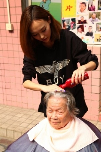 唐嫣为老人洗头。