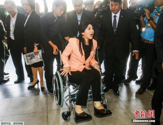 当地时间2014年3月18日，泰国佛统府，泰国看守政府总理英拉乘坐轮椅抵达皇家警察学院。  