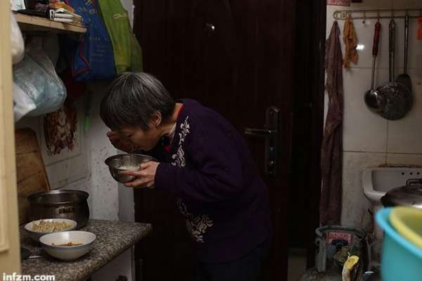 每晚给闹腾的孩子做完饭并盯着他们吃完后,郭敏才在炉台前飞快地开始吃自己的饭。 (王轶庶/图)