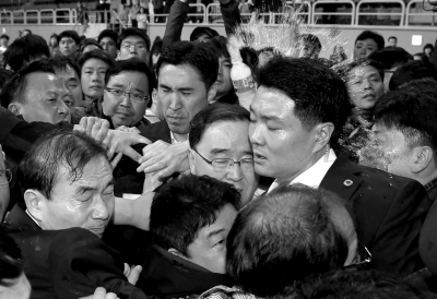 4月17日，韩国总理郑烘原抵达安置家属的体育馆慰问。他被家属围堵起来，还被情绪激动的家属泼水。　图/CFP