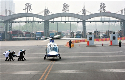 昨日，大广高速河北固安段，警方和医务人员将被解救的“受伤人质”送上警用直升机。图/东方IC