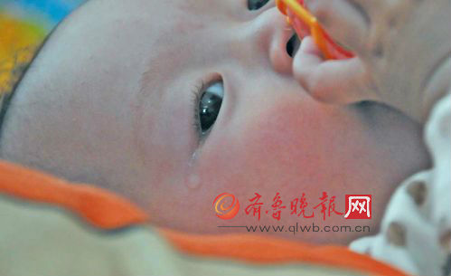 病痛让8个月大的小奕澎眼中经常含着眼泪。本报记者赵金阳李泊静摄