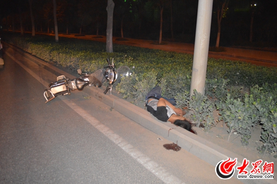 不幸身亡的男子躺在齐鲁大道东侧的绿化带里，酒后不驾车的警示再次引起人们的重视