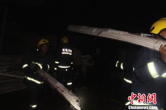 图为新疆阿勒泰地区消防人员深夜紧急转移物资。 敬兴标 摄