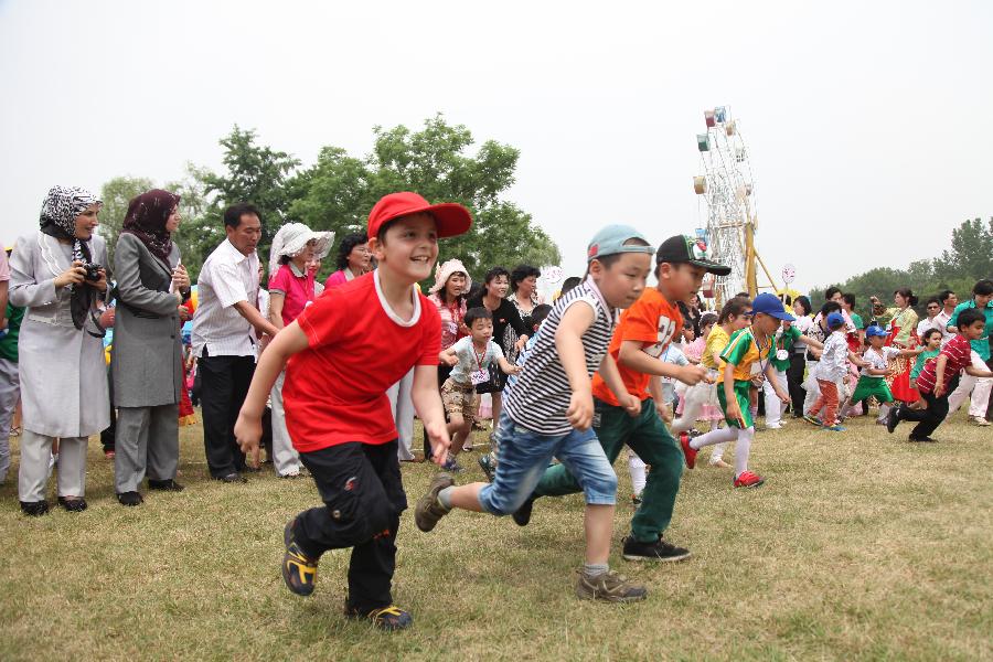 6月1日,在朝鲜平壤万景台游乐场,孩子与大人一起参加"六一"儿童节