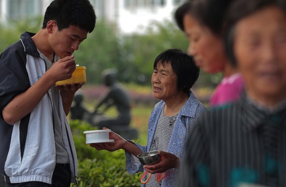 6月3日,71岁的潘奶奶送饭到学校给孙子吃,老人一直端着盛菜的碗,等着