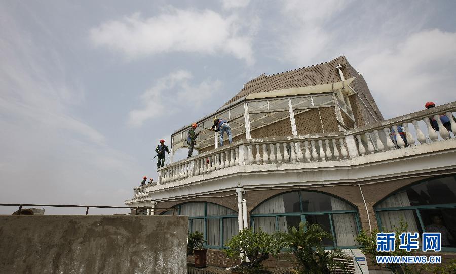 06月10日,工人在上海普陀區香山苑小區19號樓樓頂拆除違章搭建的陽光