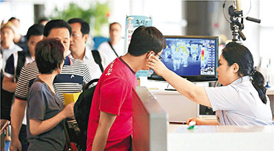 韩国机场检疫人员为旅客量体温