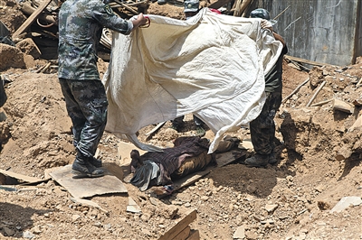 救援战士们为刚刚挖掘出的遗体盖上白布