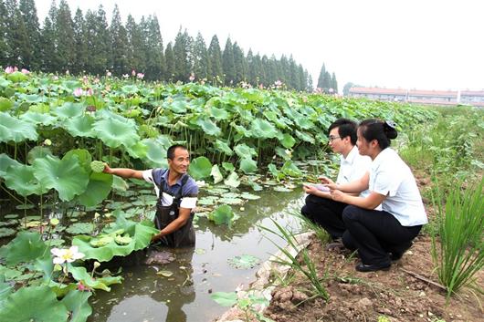 农村新报讯 图为:信贷客户经理杨柳,李凡在洪湖市大同湖农场回访喜获