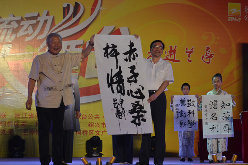 原绍兴市委副书记,绍兴市书法协会会长袁长寿(左)当场书写《赤子心