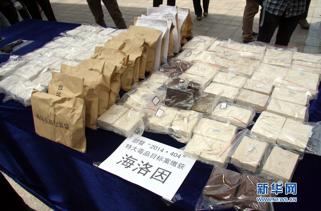 衡阳特警在特大贩毒现场缴获的毒品和毒资展示台前护卫图片:cfp