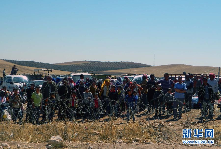 9月22日，在土耳其桑利乌尔法省与叙利亚接壤的边境，叙利亚难民等待进入土耳其。