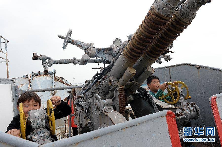 10月4日,兩位小朋友在103長春號驅逐艦上體驗高射炮的操作性能.