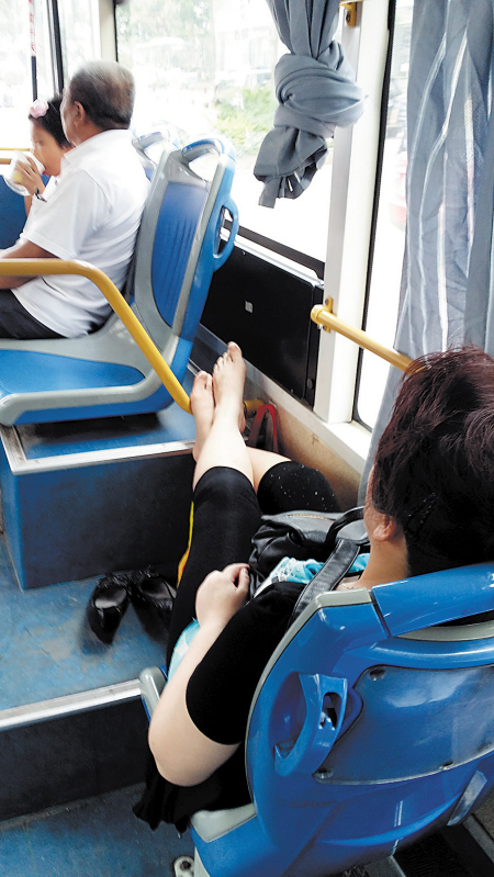 女子公交车上脱鞋赤脚跷二郎腿搭横杆上图