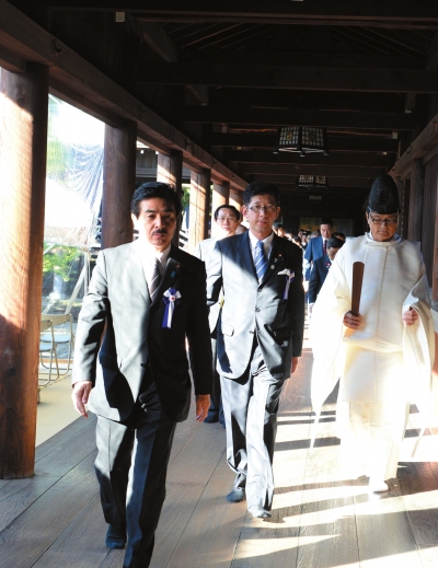 10月17日，在日本东京靖国神社本殿，一名祭司引导一些日本国会议员参拜。新华社发