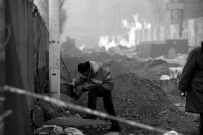 火灾现场旁，燃气公司工作人员检测地面燃气浓度。京华时报记者谭青摄