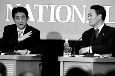12月1日，在日本东京记者俱乐部，日本首相安倍晋三（左）在讨论会上阐述观点。新华社发