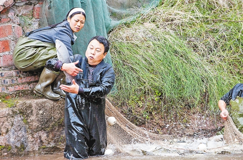 三峡移民温定军在自己水产公司的鱼塘里撒网捕鱼 新华社发