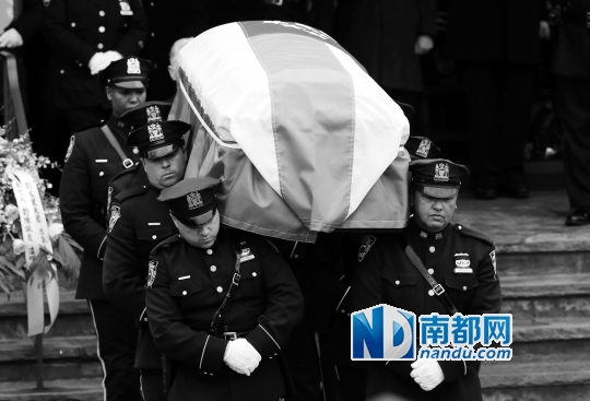 1月4日，在美国纽约为遇害华裔警员刘文健举行的葬礼上，警员肩扛棺椁走出殡仪馆。 新华社/美联