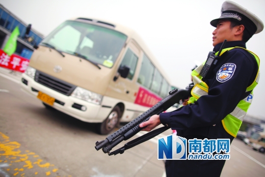 昨日,交警配枪执勤,对过往客车进行检查 南都记者 王子荣 摄