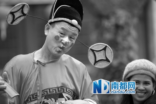 昨日，深圳市南山区，在锦绣中华园区内，一位小丑跟游客拍照留念。