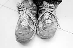 被遣返人员脚下这双“伤痕”累累的鞋,透露了其国外生活的艰辛。
