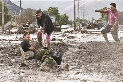 3月26日，智利科皮亚波，人们艰难行走在泥地中 供图/IC