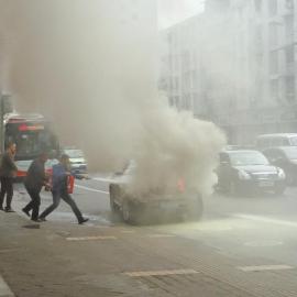 4月10日，在成都羊市街，一辆轿车突然起火，3名公交司机冲上去灭火。（图由目击者提供）