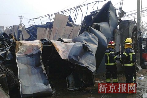 消防员喷水防止复燃。新京报记者 鲁千国 摄