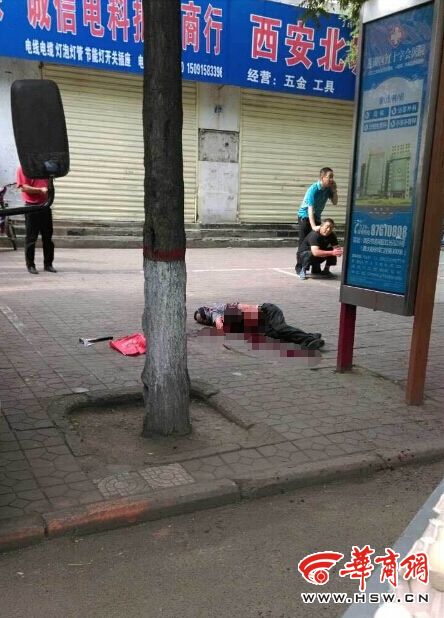 惨案,一名男子倒在公交站旁人行道上,肚子已经被利器划开,肠子流出来
