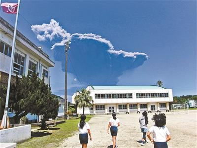 5月29日，日本鹿儿岛县屋久岛，学生看着口永良部岛的火山喷发，火山灰直冲云霄 供图/IC