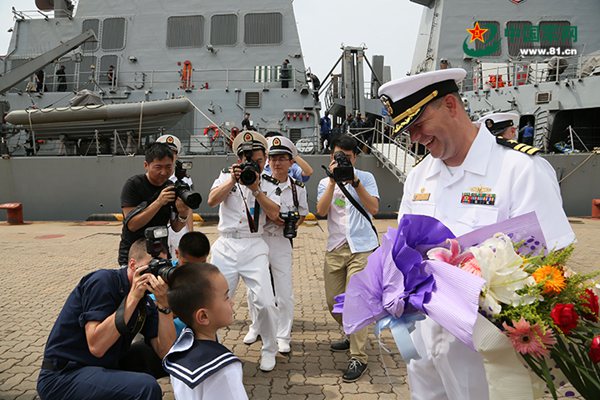 原文配圖:小孩為美國海軍驅逐艦艦長獻花.