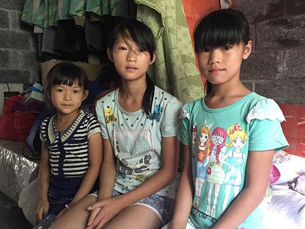 渔洞村的女孩燕子、丹丹和堂妹菊子坐在卧室中，这三个女孩都是父母在外打工的留守女童（7月30日摄）。新华社记者 张莺 摄