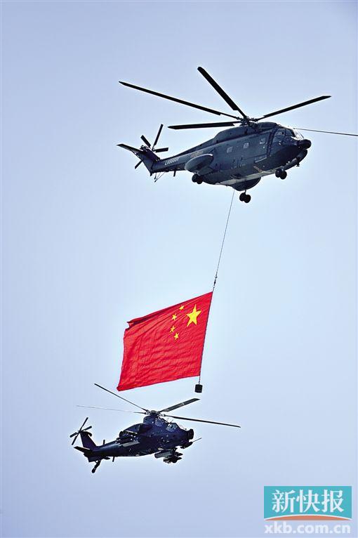 悬挂着中华人民共和国国旗和中国人民解放军军旗的空中护旗方队率先