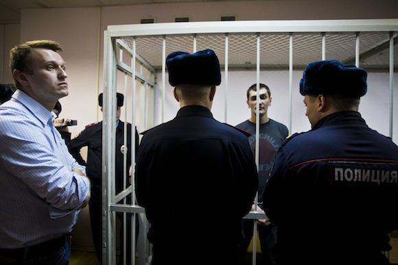 2014年12月30日,奥列格被关押在法庭上,等待判决,阿列克谢站在一旁