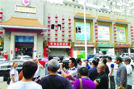 青岛宰客海鲜店成“景点”,游人“参观”拍照。 /CFP