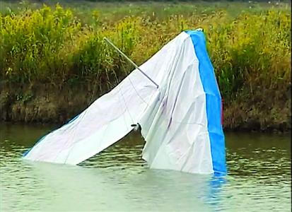 滑翔机坠落鱼塘后,机头全部没入水中。 本版图片/视频截图