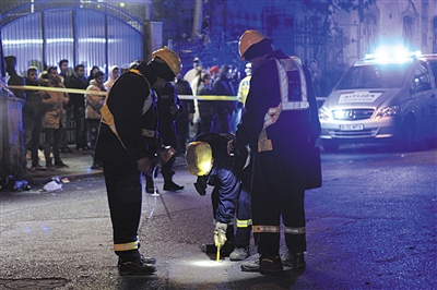 10月31日,布加勒斯特,消防员在火灾现场外工作。